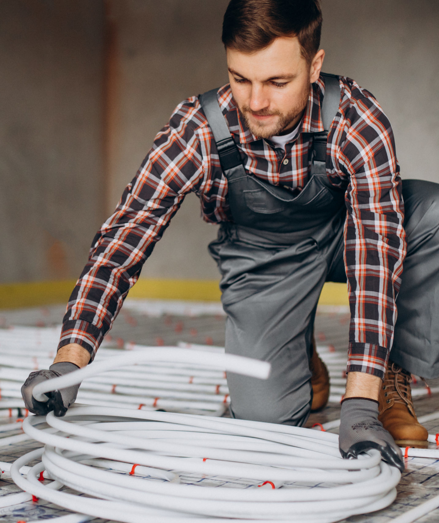 Service man instelling house heating system under the floor